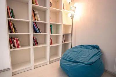 a book shelf with a blue bean bag in a room at Bicycle apartment Ljubljana in Ljubljana