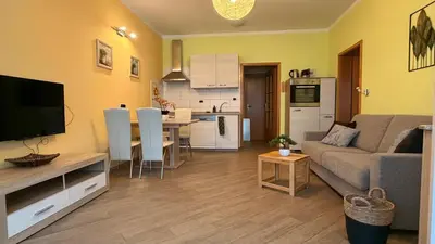 a living room with a couch and a table and a kitchen at ISONZO APARTMENT in Bovec