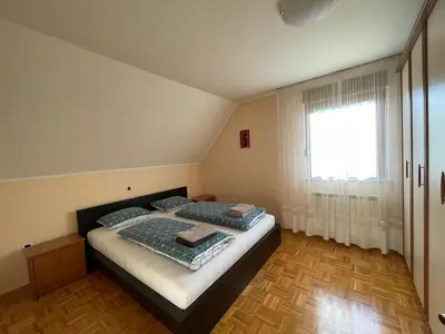 a bedroom with a bed and a large window at ISONZO APARTMENT in Bovec