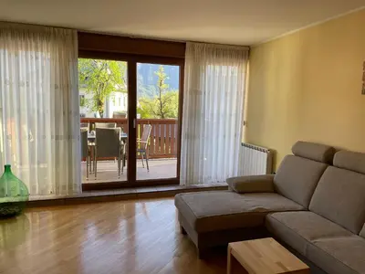 a living room with a couch and a sliding glass door at ISONZO APARTMENT in Bovec