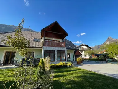 a house with mountains in the background at ISONZO APARTMENT in Bovec