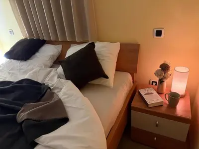 a bedroom with a bed and a night stand with a book at ISONZO APARTMENT in Bovec
