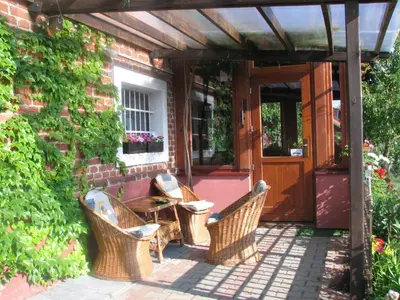 a patio with wicker chairs and a table in front of a building at Agroturism Jures in Ljutomer