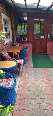 a patio with a table and chairs and a wooden door at Agroturism Jures in Ljutomer