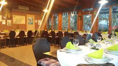 a dining room with tables and chairs and windows at Agroturism Jures in Ljutomer