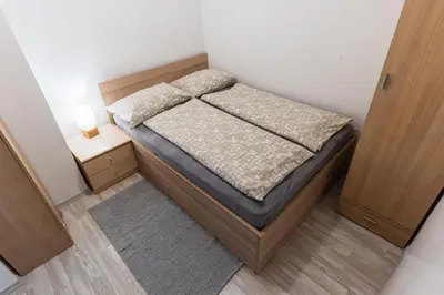 a small bedroom with a bed and a night stand at Apartment Kanalec in Tolmin
