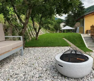 a fire pit sitting next to a couch in a yard at Apartment Kanalec in Tolmin