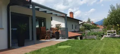 a house with a patio with a grass yard at Apartment Kanalec in Tolmin
