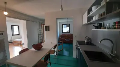 a kitchen with a sink and a living room at Nature apartment Kersnik in Bohinj