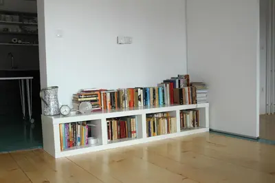 a white book shelf filled with books in a room at Nature apartment Kersnik in Bohinj