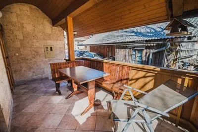 a porch with a table and chairs on a balcony at Homestay Kocka in Zgornje Jezersko