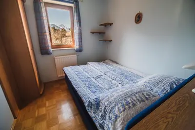 a small bedroom with a bed and a window at Homestay Kocka in Zgornje Jezersko