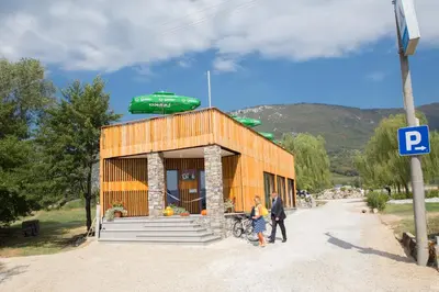 two people standing in front of a small building at Mobilehouse & Camping Lijak in Šempas