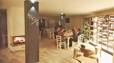a restaurant with people sitting at tables and a fireplace at Mobilehouse & Camping Lijak in Šempas