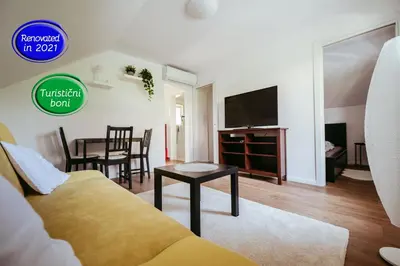 a living room with a couch and a tv and a table at Apartment Oddih in Bled
