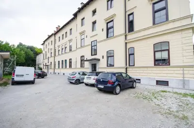a group of cars parked in front of a building at Apartment Tržaška with free parking in Ljubljana