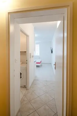 a hallway with a door leading to a laundry room at Apartment Tržaška with free parking in Ljubljana