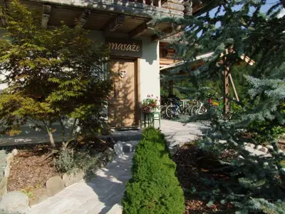 a house with a tree in front of a building at Apartments Čebelica in Bohinj