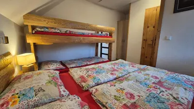 a bedroom with two beds and a bunk bed at Apartments Čebelica in Bohinj