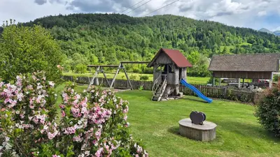 a garden with a playground and a swing set at Apartments Čebelica in Bohinj