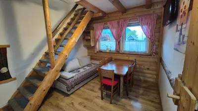 a room with a table and a couch and a staircase at Apartments Čebelica in Bohinj