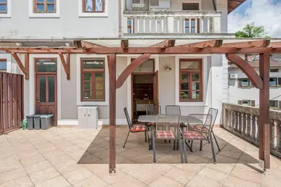 a wooden pergola with a table and chairs on a patio at Apartma Most in Most na Soči