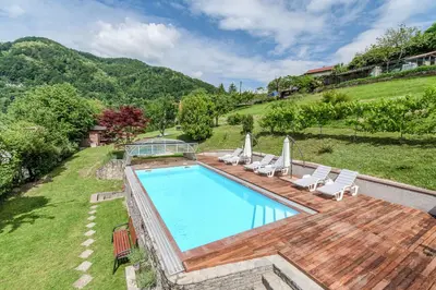 an outdoor swimming pool with chairs and umbrellas at Apartma Most in Most na Soči