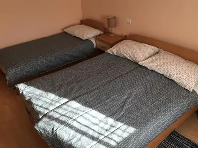 two beds in a small room with the sunlight shining on them at Guest house Okrepčevalnica Zemonska vaga in Ilirska Bistrica