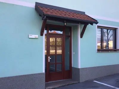 a blue building with a door and a red roof at Guest house Okrepčevalnica Zemonska vaga in Ilirska Bistrica