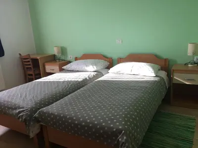 two beds sitting next to each other in a room at Guest house Okrepčevalnica Zemonska vaga in Ilirska Bistrica