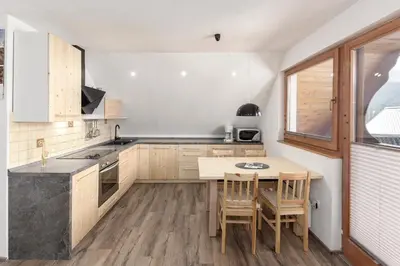 a kitchen with a table and chairs and a table and a window at Old Mill House in Bohinj