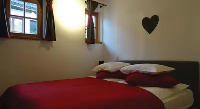 a bedroom with a bed with a red blanket and pillows at Apartma Pri Štruklju in Kranjska Gora