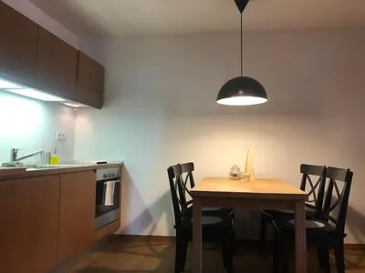 a kitchen with a table and chairs and a light at Apartma Pri Štruklju in Kranjska Gora