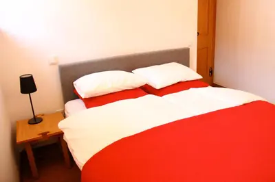 a red and white bed with two pillows on it at Apartma Pri Štruklju in Kranjska Gora