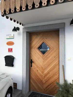 a wooden garage door with a cross on it at Apartma Pri Štruklju in Kranjska Gora