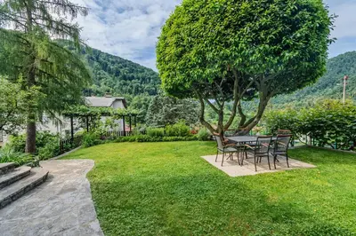 a table and chairs in a yard with a tree at Hisa Taljat in Most na Soči