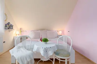 a bedroom with a white bed with a table and chairs at Apartma Sara in Bohinj