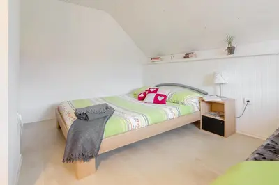 a bedroom with a bed with a blanket and a lamp at Apartma Sara in Bohinj