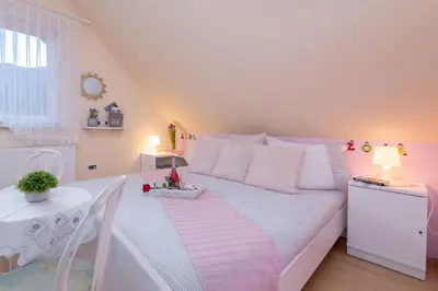 a white bed in a small room with a table at Apartma Sara in Bohinj