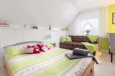 a bedroom with a bed and a couch at Apartma Sara in Bohinj