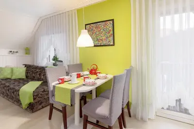 a dining room with a table and chairs and a couch at Apartma Sara in Bohinj