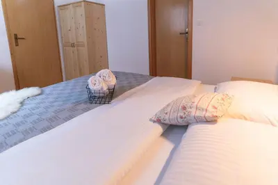two beds in a bedroom with towels on them at Brunarica in Bohinj