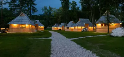 a row of cottages at night with lights on at Slovenia Eco resort in Stahovica