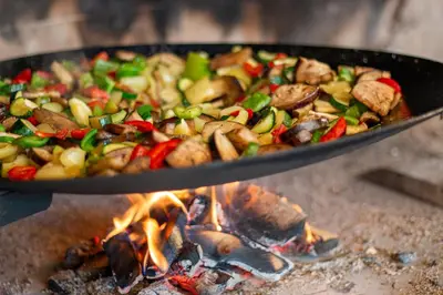 a pan of food is cooking over a fire at Slovenia Eco resort in Stahovica