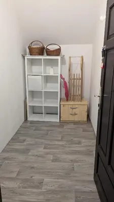 a room with a white book shelf and a chair at Apartma BRINA, new bathroom in nov 24 in Kranjska Gora