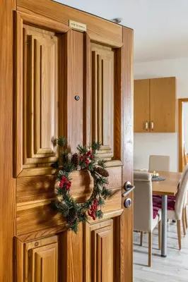 a wooden door with a christmas wreath on it at Apartma BRINA, new bathroom in nov 24 in Kranjska Gora