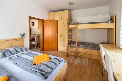a room with two bunk beds and a table at Apartma BRINA, new bathroom in nov 24 in Kranjska Gora