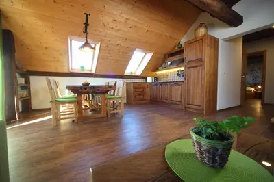 a kitchen and dining room with a wooden ceiling at Pod Ponco Apartments in Kranjska Gora
