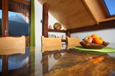 a dining room table with a bowl of fruit on it at Pod Ponco Apartments in Kranjska Gora