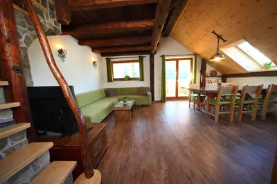 a living room with a green couch and a table at Pod Ponco Apartments in Kranjska Gora